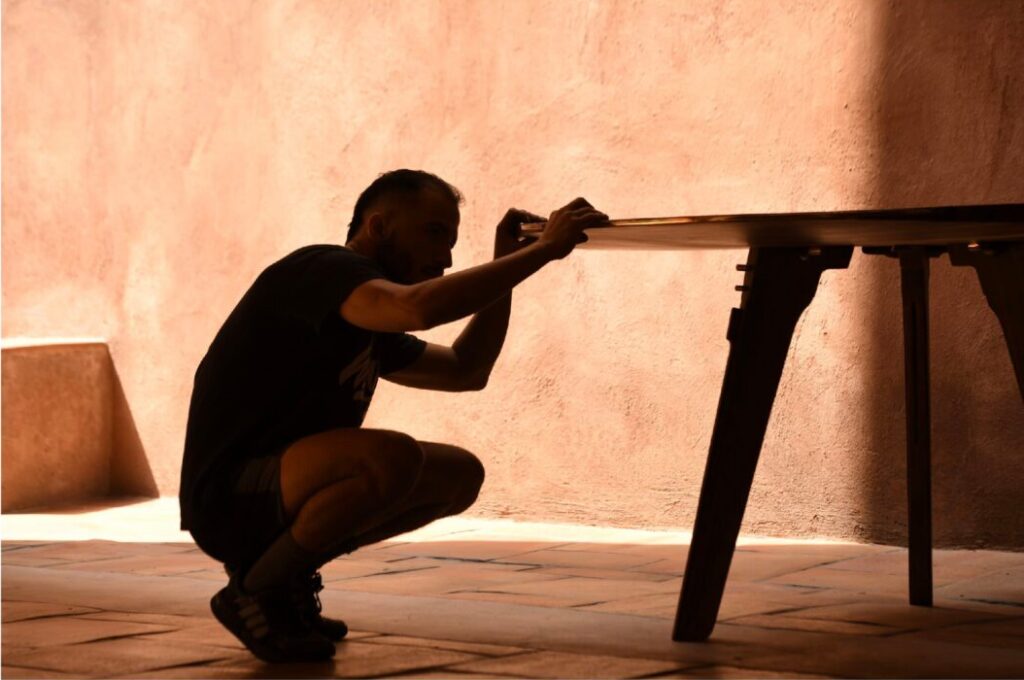 man looking at a wood table - hand-carved parota wood table