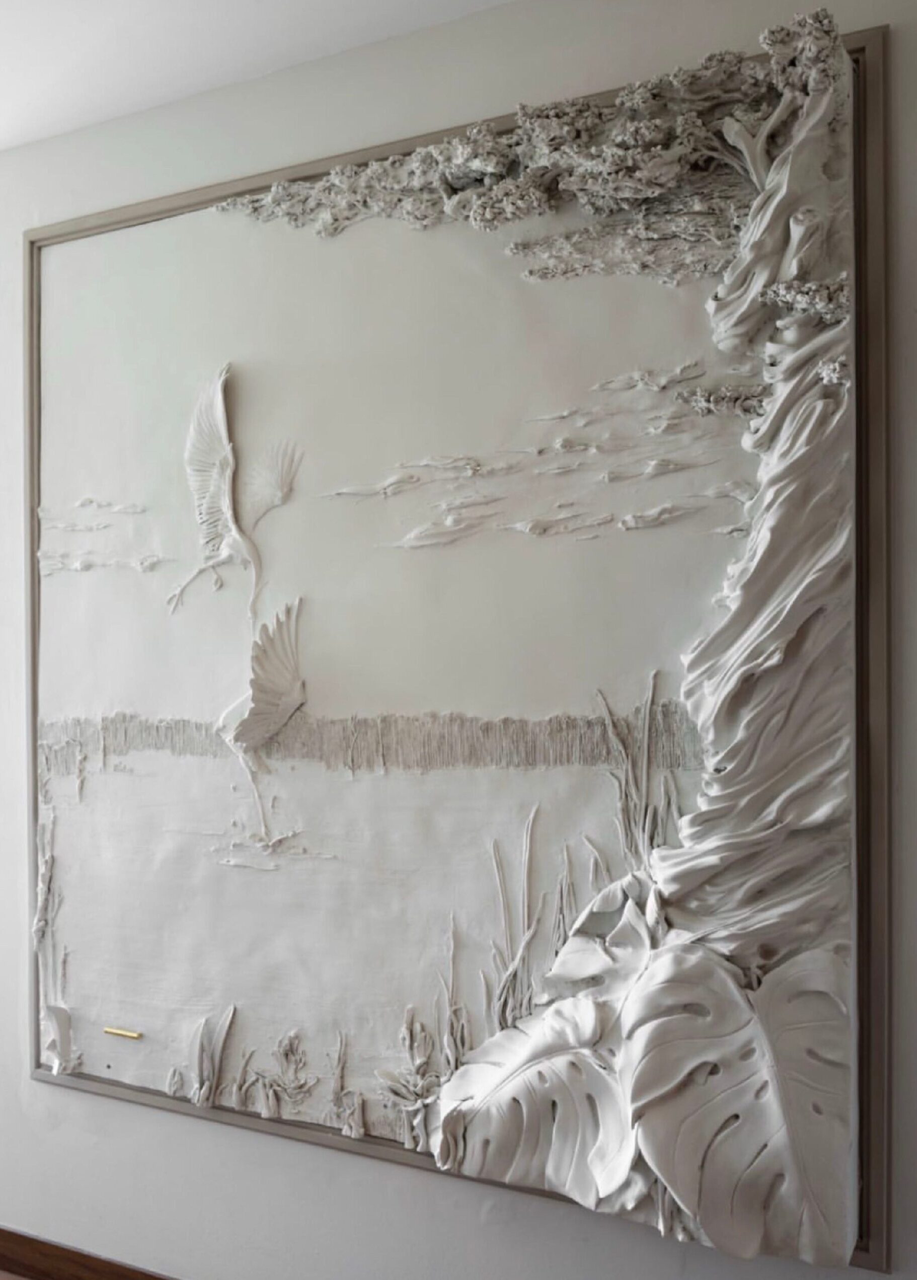 Textured wall sculpured. Herons and trees around a lake.