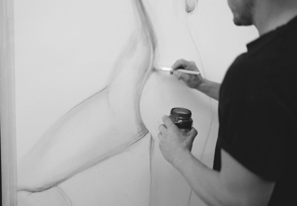 man drawing with charcoal black and white